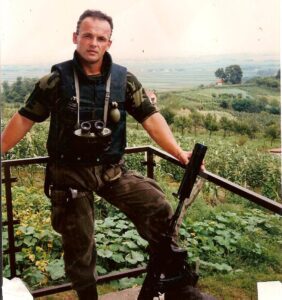 In uniform with binoculars above vineyards